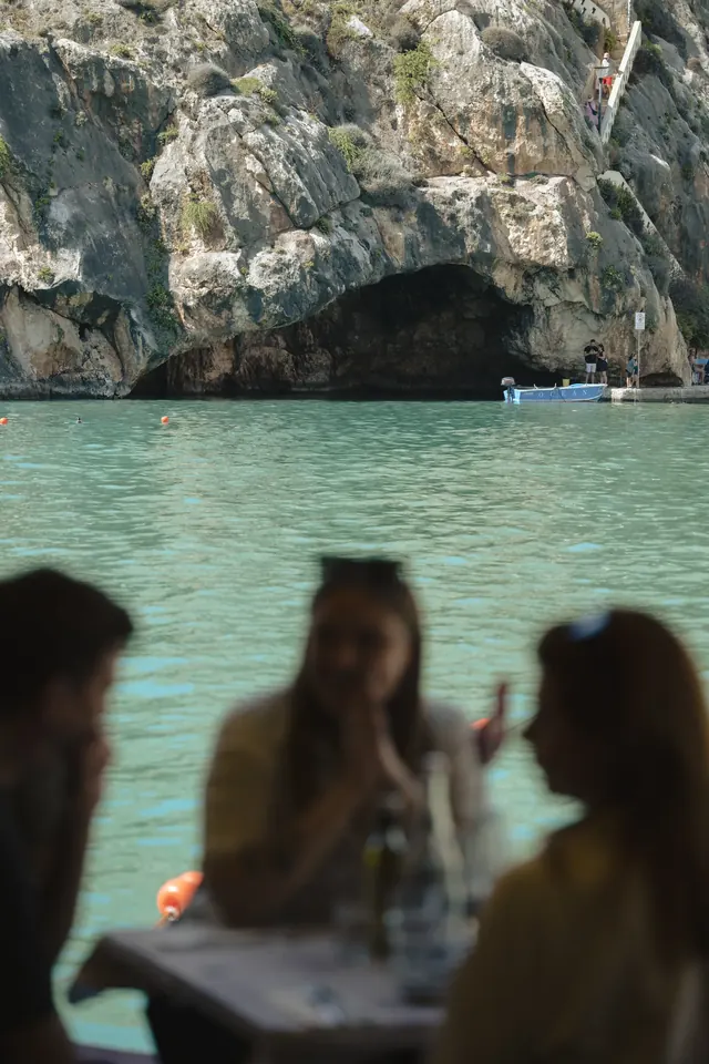 View across Xlendi Bay from a waterside table